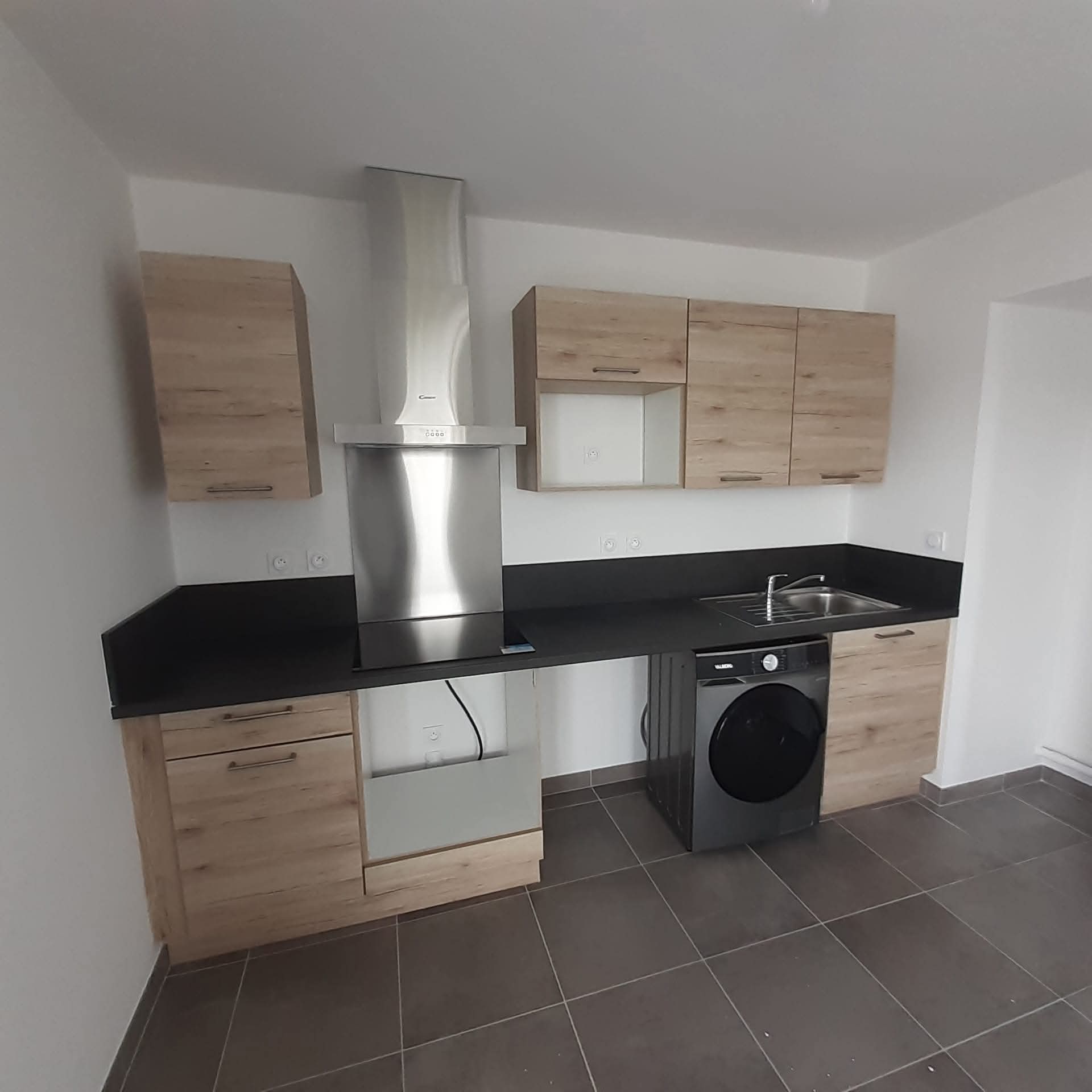 Cuisine équipée installée avec plan de travail et façades assorties